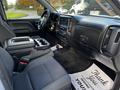 Interior view of a 2017 GMC Sierra 1500 showing the driver's side with black fabric seats a center console and dashboard controls