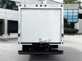 A white 2021 Ford E-450 box truck viewed from the rear with a blank cargo area and large rear doors