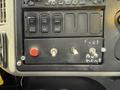 A control panel featuring several switches and buttons labeled for various functions including fuel and equipment controls