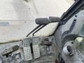Close-up view of the control pedals and levers inside a 2018 John Deere 350 vehicle
