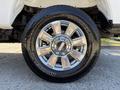 Close-up of a shiny chrome wheel and tire from a 2017 Ford F-350 SD featuring Michelin branding and a multi-spoke design