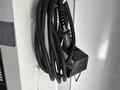 A 2017 Ford Econoline with a coiled charging cable attached to a wall-mounted charger