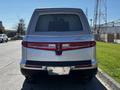 A rear view of a silver 2013 Lincoln MKT featuring distinctive tail lights and a sleek design