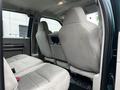Interior view of the back seat of a 2008 Ford F-550 with two cloth seats and a center armrest
