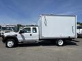 A 2008 Ford F-450 SD with a white box truck body is parked side on showing its large size and robust build