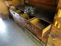 A wooden workbench featuring multiple open drawers and a metal vise attached to the side