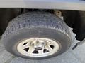 A close-up view of the tire and rim of a 2014 GMC Sierra 1500 featuring a rugged tread pattern and a silver rim with a black center cap