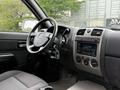 Interior of a 2012 GMC Canyon featuring a steering wheel and dashboard with audio controls and air conditioning knobs