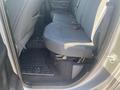 Interior view of the back seat of a 2021 RAM 1500 with gray fabric upholstery and a floor mat visible