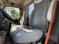 The interior of a 2007 International 9200i truck focusing on the driver's seat with a gray fabric cover and a wooden cane resting against it