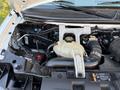 Engine compartment of a 2015 GMC Savana featuring various components such as hoses a reservoir and the battery