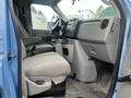 Interior view of a 2010 Ford Econoline showing driver's seat dashboard and front passenger area with gray upholstery and various controls