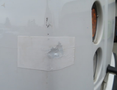 A white 2020 Chevrolet Express van with a small dent and a patch on the side panel