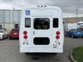 White 2013 Chevrolet Express with a wheelchair accessibility sign on the back two red brake lights and a large rear window