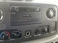 Dashboard of a 2010 Ford Econoline featuring a radio display with buttons for tuning volume and climate control settings