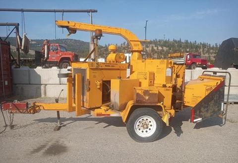 A yellow 1993 Bandit 200 wood chipper with a towable trailer design featuring a chute, control panel, and various mechanical components visible