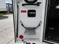 The rear door of a 2013 Chevrolet Express with a handle and a step plate along with an emergency access label and a red circle symbol