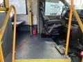 Interior of a 2018 Chevrolet Express showing the driver's seat and steering wheel with a yellow handrail and floor space visible