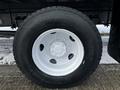 The image shows a close-up of a black tire mounted on a white wheel from a 2019 Hino 338 24 foot cube truck