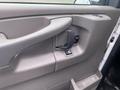 Interior door panel of a 2014 Chevrolet Express featuring a door handle window control and storage compartment