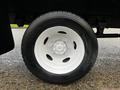 A close-up of a white wheel on a 2006 Hino 155 truck showing a smooth tire tread and shiny rim