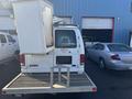 A white 2008 Ford Econoline van with a bucket lift attached to the roof and a metal platform at the rear