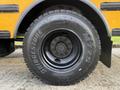 Close-up of a Black Bridgestone M775 tire mounted on a wheel of a 2013 International 4300 with visible lug nuts and a shiny rim