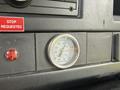 A gauge displaying temperature readings with a silver circular frame set in a black dashboard panel of a 2017 Chevrolet Express