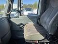 Interior view of a 2007 International 7300 truck's driver's seat showing wear and tear with a gray fabric covering and adjustable lever on the side