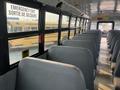 Interior of a 2007 Freightliner B2 school bus showing rows of gray seats and large windows with an emergency exit sign