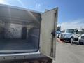 A 2015 Ford F-450 SD with an open cargo area revealing metal walls and a tire visible inside