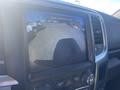 A dashboard screen displaying a rearview camera image of a 2021 RAM 1500 truck showing the surroundings behind the vehicle