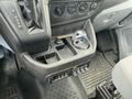 Interior console of a 2019 Ford Transit showing gear shifter buttons control knobs and a cup holder with a metal object inside