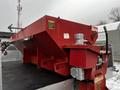 A red truck-mounted salt spreader with a large hopper and controls attached to a 2008 Ford F-450 SD