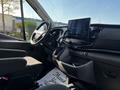 Interior of a 2022 Ford Transit featuring a modern dashboard with a large touchscreen display and standard vehicle controls