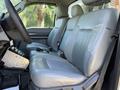 Interior of a 2011 Ford F-550 showing two gray leather front seats with a console in the middle and a view of the dashboard and gear shift
