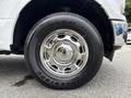 A close-up of a chrome wheel and tire on a 2018 Ford F-150 featuring a Bridgestone Dueler H/T tire with a shiny hubcap