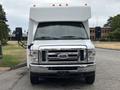 Front view of a 2014 Ford E-350 with a white exterior and orange lights on the roof
