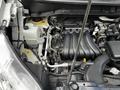Engine compartment of a 2020 Nissan NV200 featuring various components including the engine block tubing and cooling system