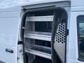 A 2013 Ford Transit Connect with open rear doors showing metal shelves inside for storage
