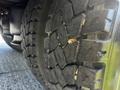 Close-up of a tire tread on a 2004 Freightliner M2 showcasing deep grooves and a rugged surface indicating heavy use and traction features