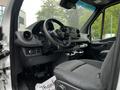 Interior of a 2019 Mercedes-Benz Sprinter showing the dashboard steering wheel and driver's seat with black fabric upholstery and control panels