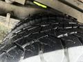 Close-up of a tire with deep tread patterns on a 2015 Chevrolet Express showing water droplets on the surface