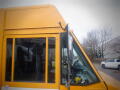 A yellow 2008 Freightliner MT45 Chassis with a large front window and side mirror visible