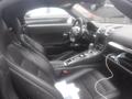 Interior of a 2016 Porsche Boxster featuring black leather seats a central console and a steering wheel with controls