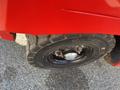 Close-up of a black tire mounted on a shiny rim with visible nuts and the tread labeled "SOLID TIRE" on a red vehicle