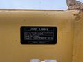 A yellow identification plate for a John Deere 310SJ 4x4 Wheel Loader Extended Hoe 4 in 1 with part number AT447279 and capacity MULTI-PURPOSE 92 IN