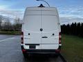 A white 2017 Mercedes-Benz Sprinter van viewed from the rear with a simple design featuring the Mercedes logo and minimal branding on the back doors