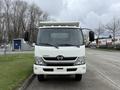 Front view of a white 2014 Hino 195 truck with a flatbed and large mirrors