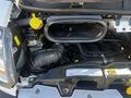 A 2021 RAM Promaster engine compartment showing the air intake manifold and various engine components with a yellow coolant cap and several hoses